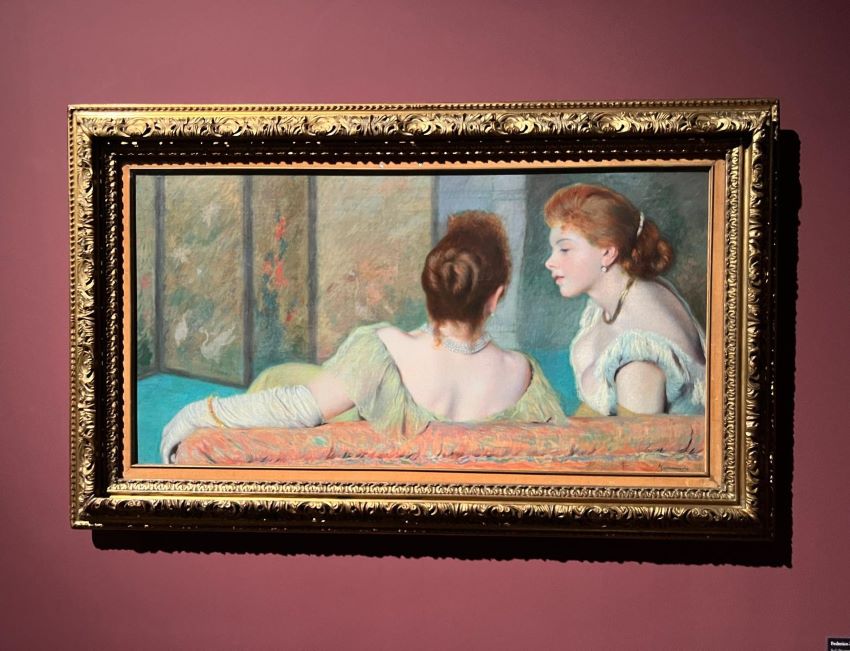 Due donne della buona borghesia, intente a dialogare di spalle sedute su un divano